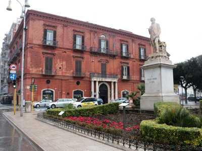 Siamo ora all�angolo di piazza Massari, dove incontriamo Palazzo Diana. Sede della banca della famiglia omonima fino al suo fallimento avvenuto a fine 800, ha un caratteristico colore rosso mattone e un portone dalla cornice di pietra bianca affiancato da quattro semicolonne della stessa tonalit�